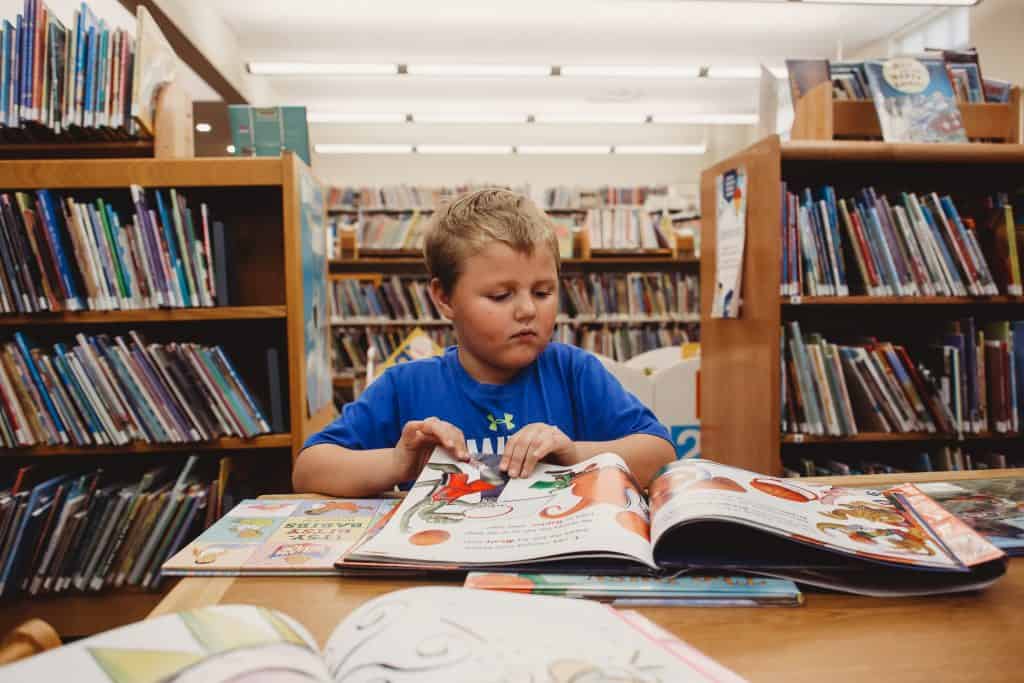 boy looking at a book in the library