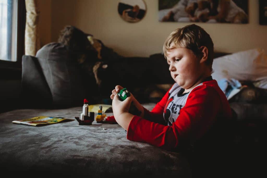 6 year old boy playing with legos he got as a gift