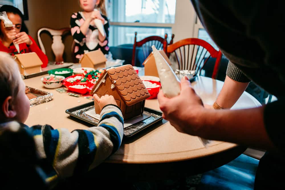 kid decorating a gingerbread house